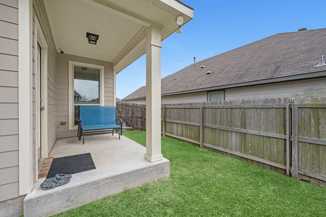 a view of backyard with wooden fence and a bench