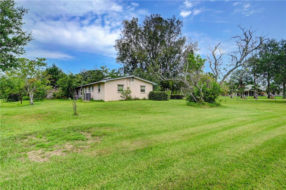 17700 Southwest 68th Court Southwest Ranches, FL 33331 - Photo 16 of 23 a white house with a big yard and large trees