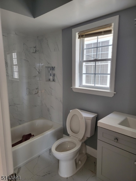 232 Amity Street, Unit 1 Elizabeth, NJ 07202 - Photo 11 of 11 a bathroom with a granite countertop toilet a sink and a bathtub