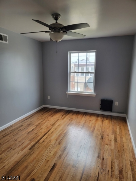 232 Amity Street, Unit 1 Elizabeth, NJ 07202 - Photo 4 of 11 an empty room with wooden floor and windows