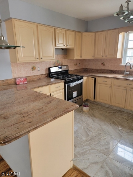 232 Amity Street, Unit 1 Elizabeth, NJ 07202 - Photo 9 of 11 a kitchen with granite countertop a sink a stove and cabinets