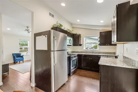 a kitchen with stainless steel appliances granite countertop a refrigerator a sink a stove a microwave and island