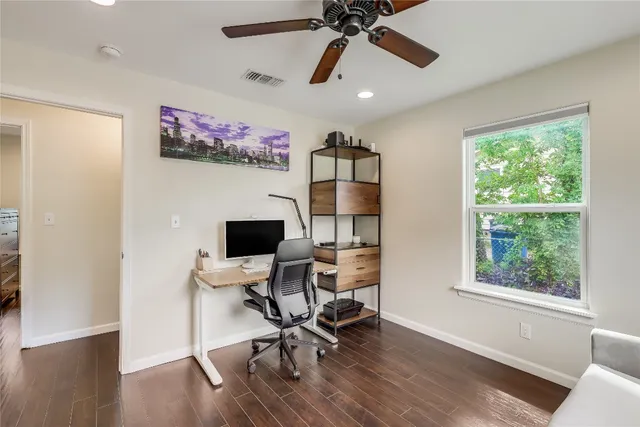 a view of a workspace with furniture and a window