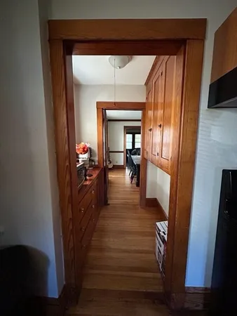 a view of a hallway view with living room and wooden floor