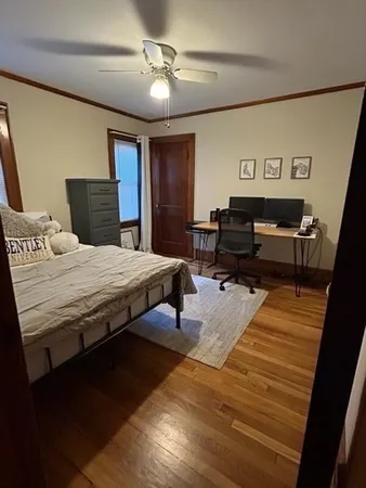 a bedroom with a bed and wooden floor