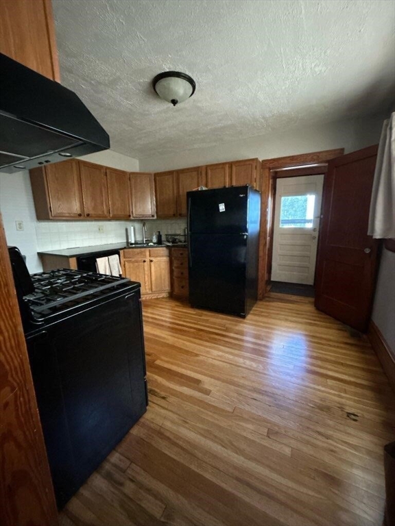 207 South Street, Unit 1 Waltham, MA 02453 - Photo 6 of 8 a kitchen with stainless steel appliances granite countertop a stove and a refrigerator