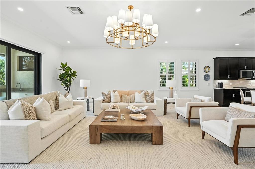 Living room featuring recessed lighting, crown molding, and a chandelier