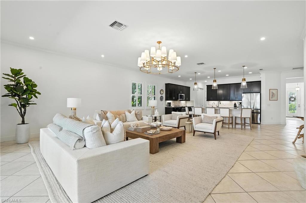 4649 Abaca Circle Naples, FL 34119 - Photo 2 of 32 a living room with furniture and a chandelier