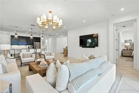 a living room with furniture a flat screen tv and kitchen view