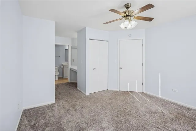 an empty room with a ceiling fan and a bathroom