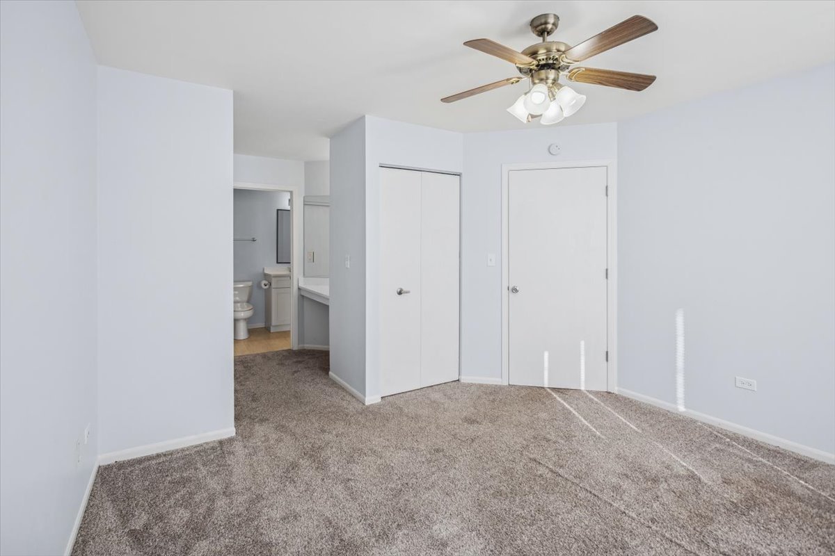 120 Cathy Lane, Unit 120 Mount Prospect, IL 60056 - Photo 14 of 20 an empty room with a ceiling fan and a bathroom