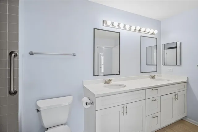 a bathroom with a double vanity sink mirror and toilet