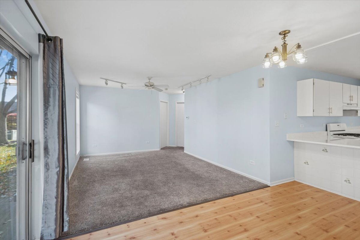 120 Cathy Lane, Unit 120 Mount Prospect, IL 60056 - Photo 3 of 20 a view of a kitchen with wooden cabinet and a ceiling fan