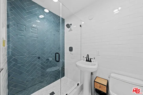 a bathroom with a sink shower and a mirror