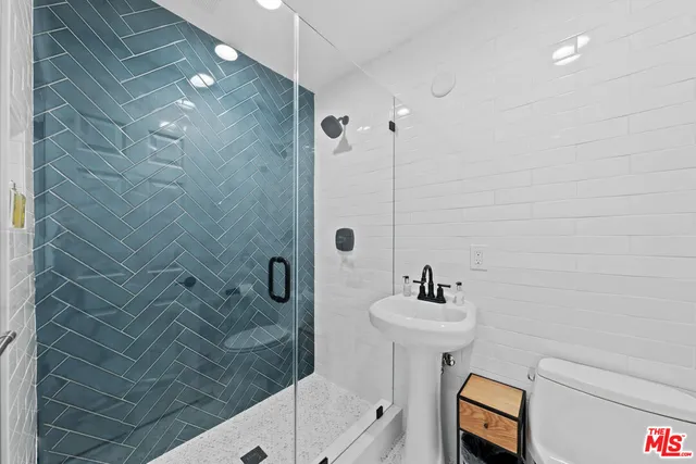 a bathroom with a sink shower and a mirror