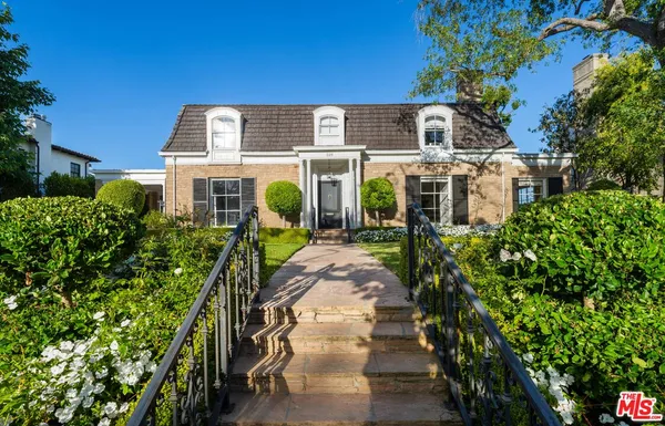 a front view of a house with a garden