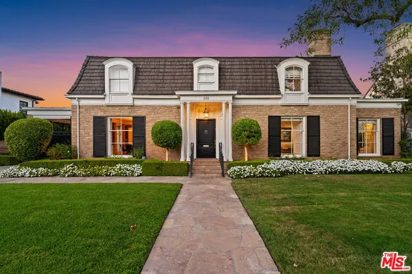 a front view of a house with a garden