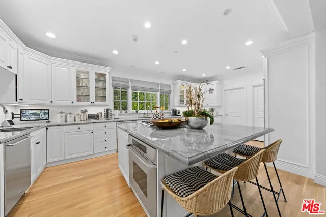 a kitchen with stainless steel appliances granite countertop a kitchen island a stove and a sink