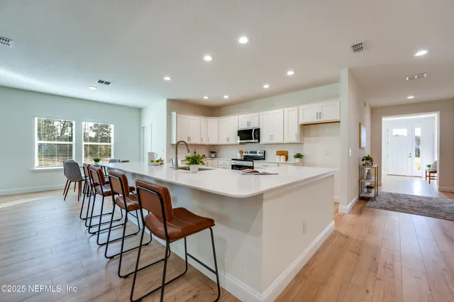 a kitchen with stainless steel appliances granite countertop a stove a sink and white cabinets