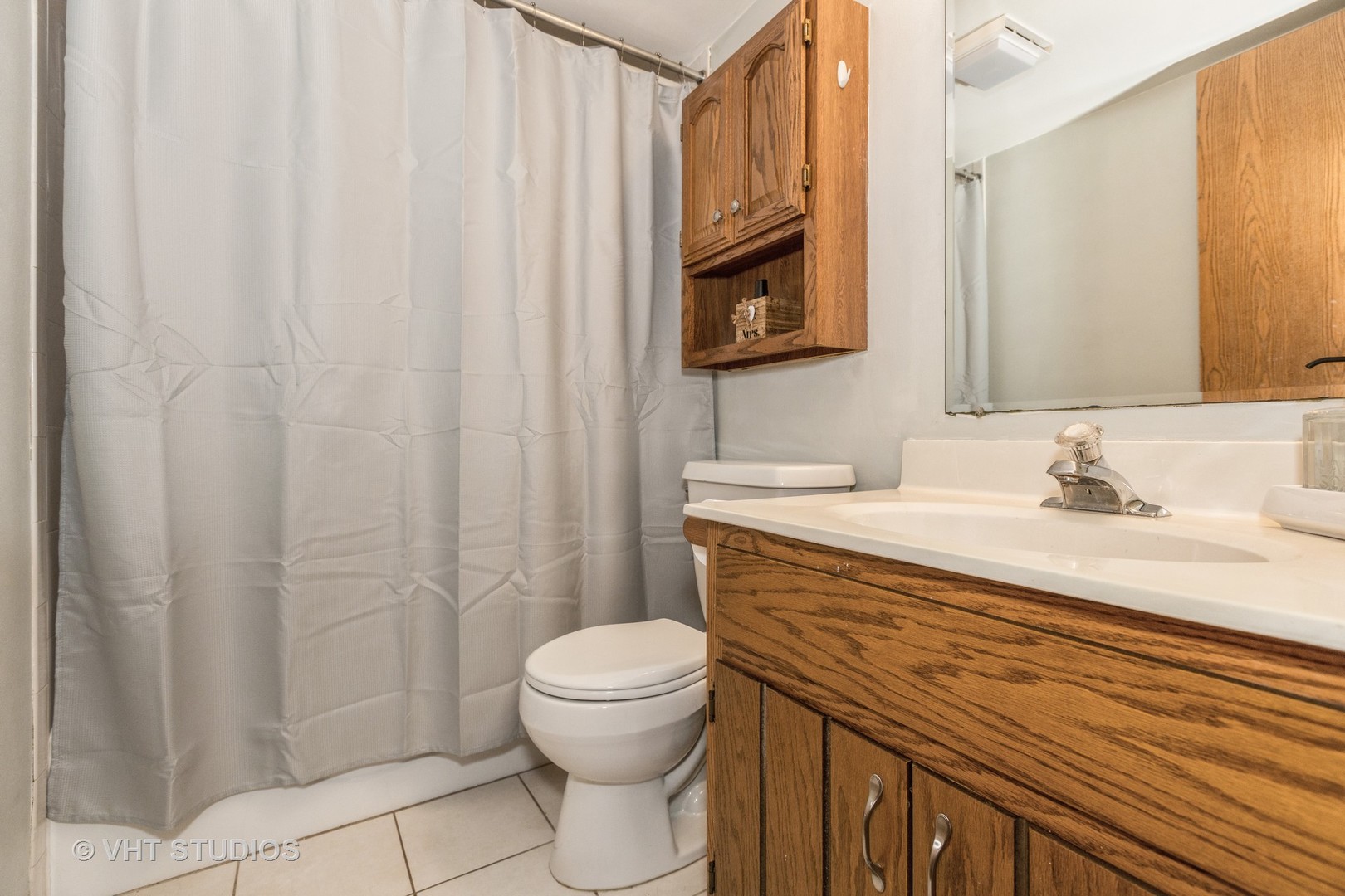 10288 SW Highway, Unit 1D Chicago Ridge, IL 60415 - Photo 10 of 12 a bathroom with a sink a toilet and shower curtain