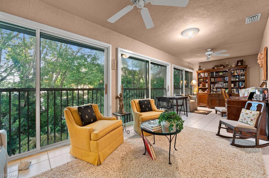 205 Via Perignon, Unit 23 Naples, FL 34119 - Photo 12 of 37 a living room with furniture and a floor to ceiling window