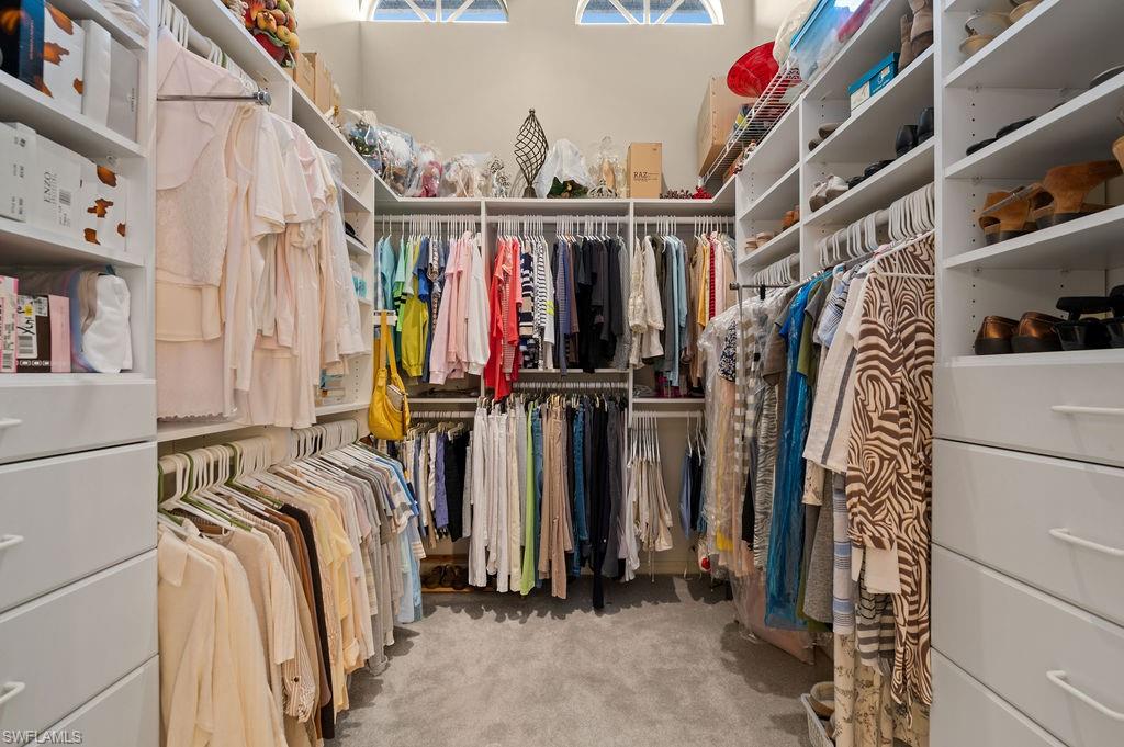 205 Via Perignon, Unit 23 Naples, FL 34119 - Photo 24 of 37 a view of walk in closet with clothes and shoes