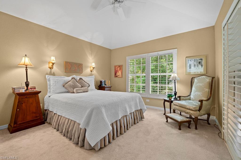 205 Via Perignon, Unit 23 Naples, FL 34119 - Photo 25 of 37 a bedroom with a bed and a chandelier