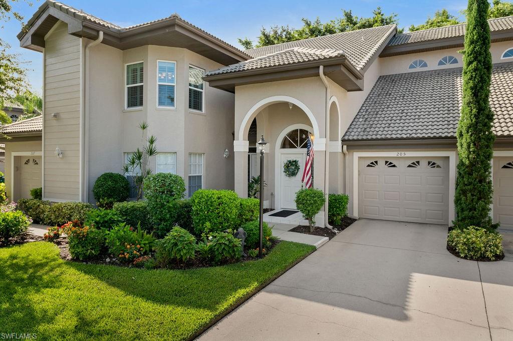205 Via Perignon, Unit 23 Naples, FL 34119 - Photo 32 of 37 a front view of a house with garden