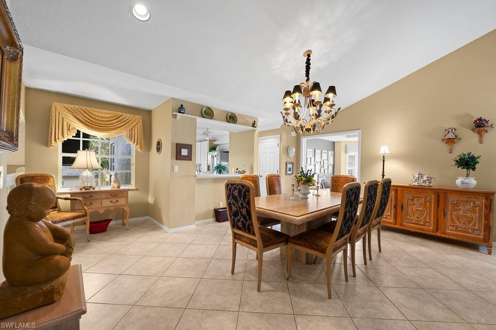 205 Via Perignon, Unit 23 Naples, FL 34119 - Photo 7 of 37 a dining room with chandelier and wooden floor