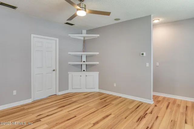 a view of empty room with wooden floor