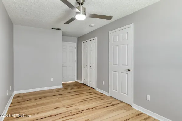 a view of a livingroom with wooden floor and a ceiling fan