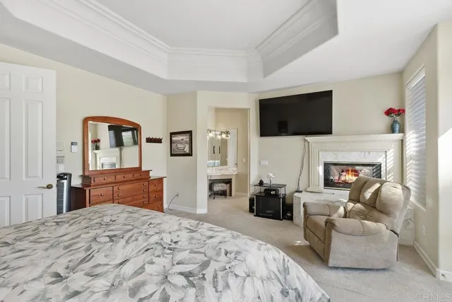 a bedroom with a bed a flat screen tv and dresser