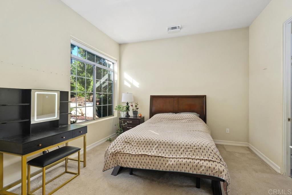 3068 Southwind Lane Vista, CA 92084 - Photo 24 of 44 a bedroom with a bed and a flat tv screen next to a window