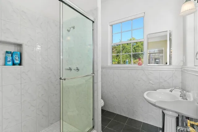 a bathroom with a sink a toilet and shower