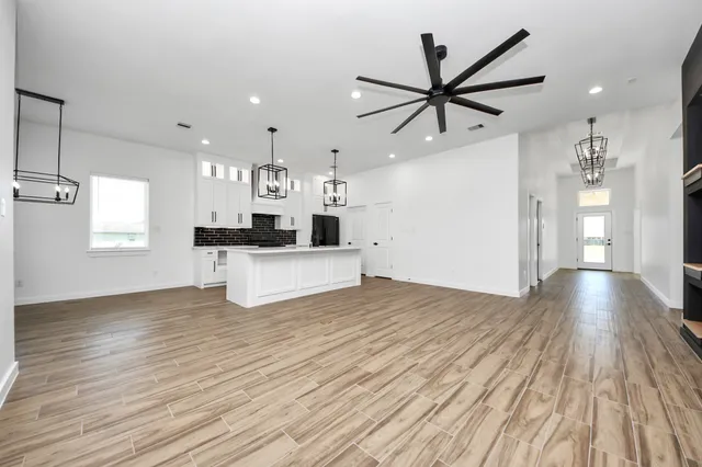 a view of a kitchen with a sink and dishwasher with wooden floor