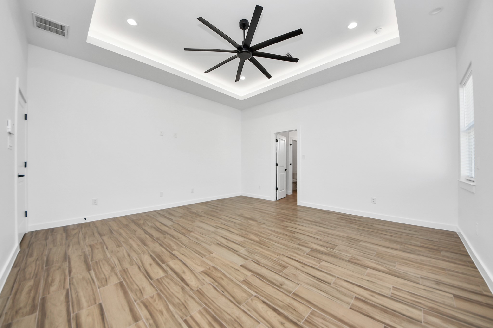 207 Manor Avenue Arcola, TX 77583 - Photo 27 of 37 an empty room with wooden floor and a ceiling fan