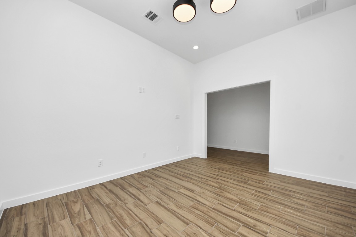 207 Manor Avenue Arcola, TX 77583 - Photo 3 of 37 a view of an empty room with wooden floor and a window