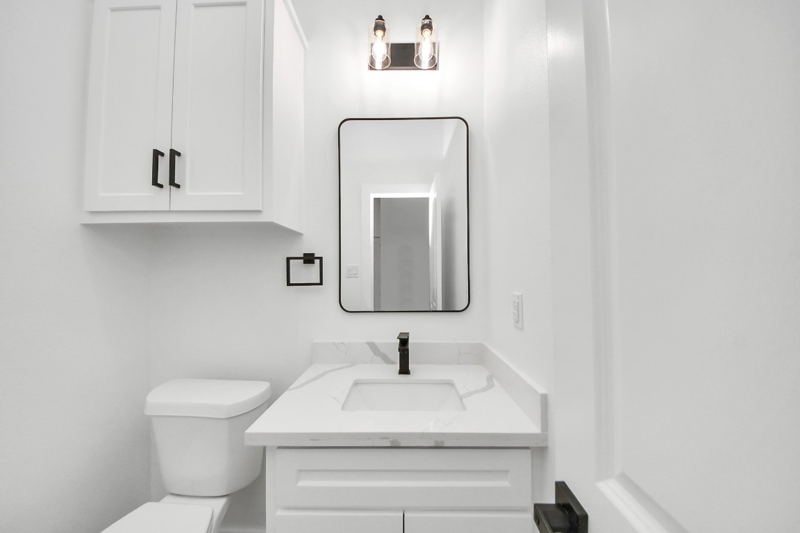 207 Manor Avenue Arcola, TX 77583 - Photo 4 of 37 a bathroom with a toilet sink and mirror