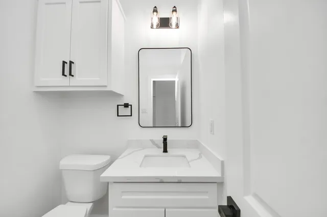 a bathroom with a toilet sink and mirror