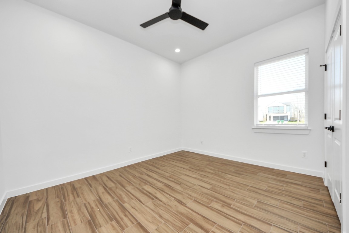 207 Manor Avenue Arcola, TX 77583 - Photo 5 of 37 an empty room with wooden floor chandelier fan and windows