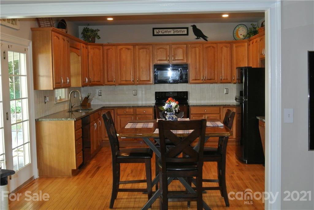1911 Coxe Road Rutherfordton, NC 28139 - Photo 16 of 37 a kitchen with stainless steel appliances granite countertop a table chairs and a refrigerator