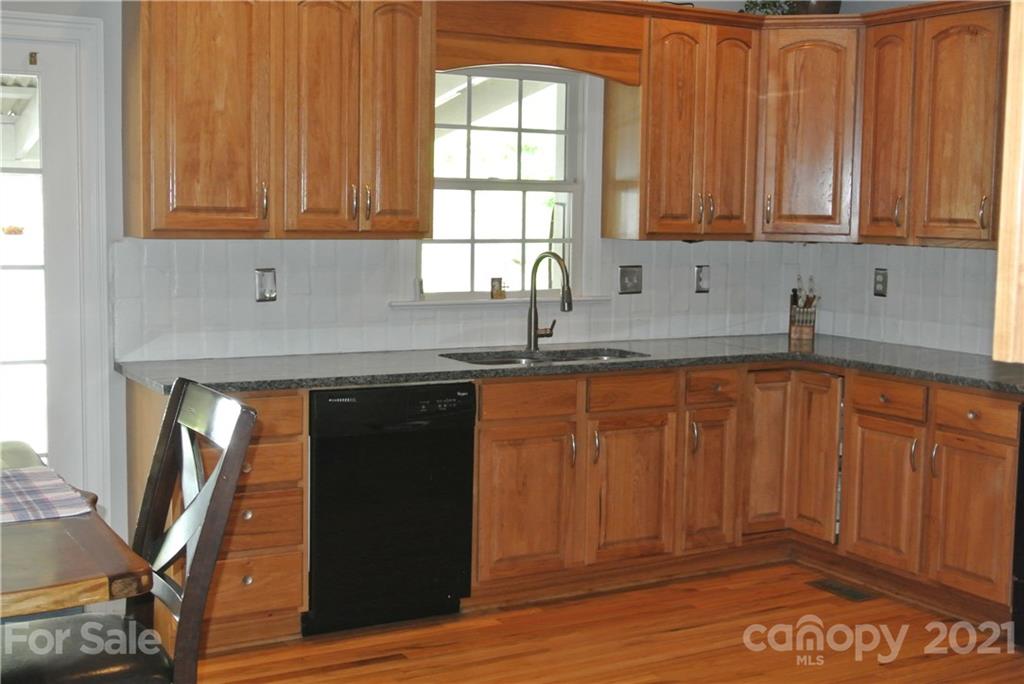 1911 Coxe Road Rutherfordton, NC 28139 - Photo 17 of 37 a kitchen with granite countertop wooden cabinets a sink and a window