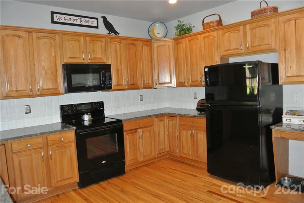 1911 Coxe Road Rutherfordton, NC 28139 - Photo 19 of 37 a kitchen with granite countertop wooden cabinets and a stove top oven
