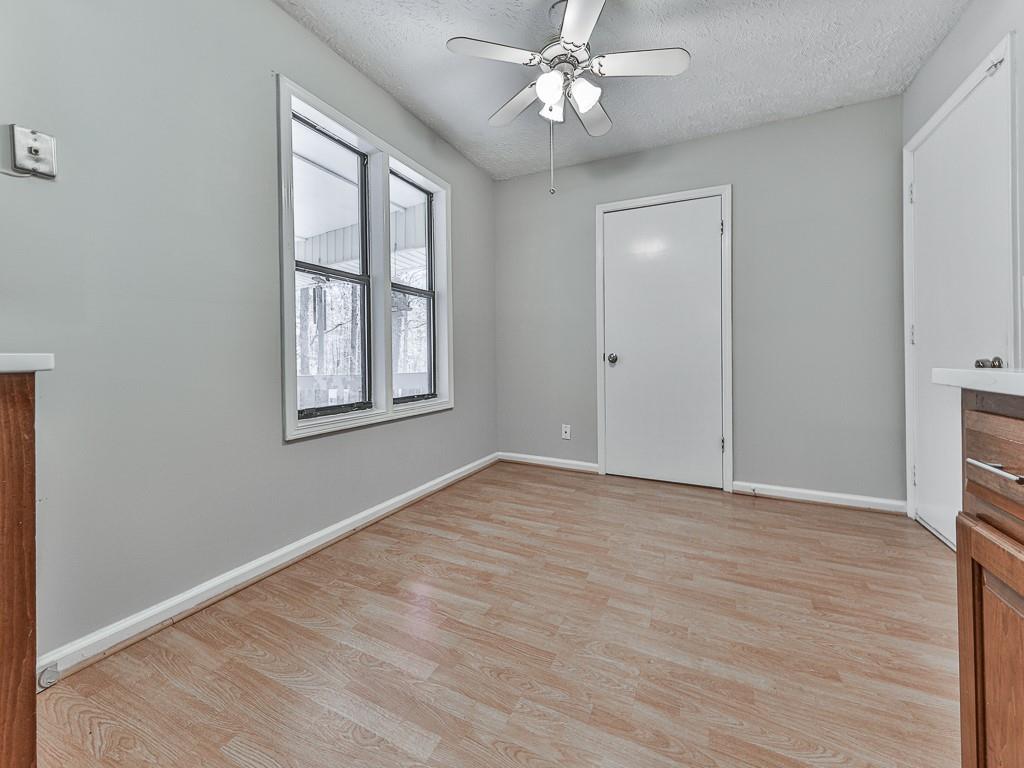 5506 Vaughn Road Woodstock, GA 30188 - Photo 12 of 33 a view of an empty room with a window and wooden floor