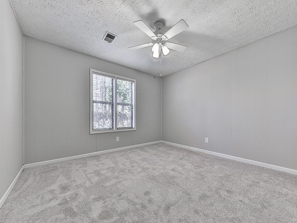 5506 Vaughn Road Woodstock, GA 30188 - Photo 17 of 33 an empty room with windows and chandelier fan