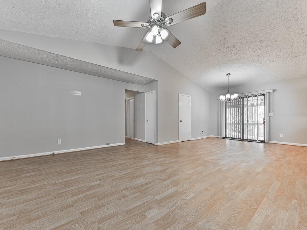 5506 Vaughn Road Woodstock, GA 30188 - Photo 4 of 33 a view of an empty room with chandelier fan and wooden floor