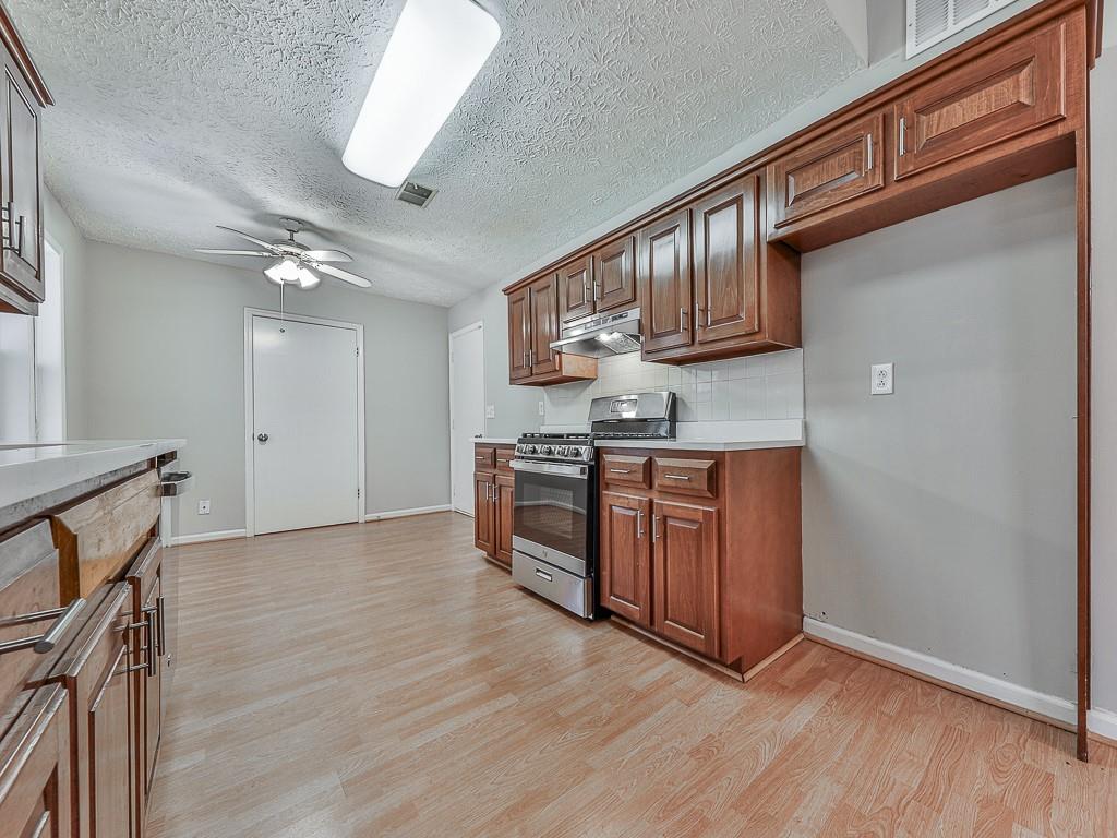 5506 Vaughn Road Woodstock, GA 30188 - Photo 9 of 33 a kitchen with stainless steel appliances granite countertop a stove a sink and a refrigerator