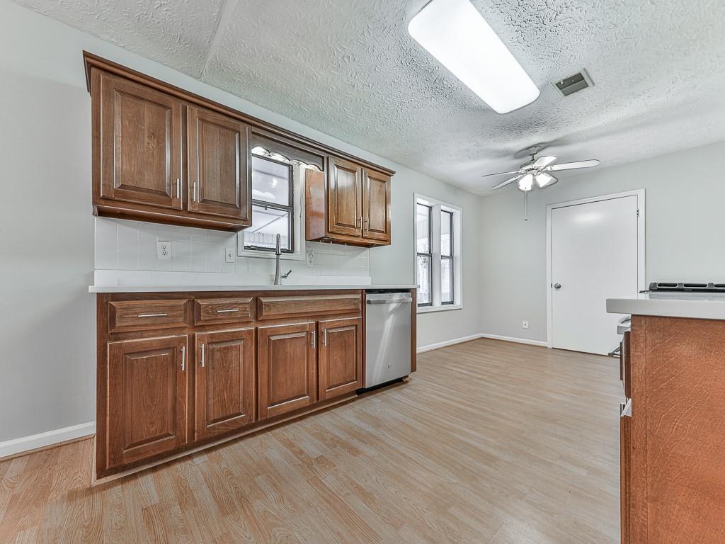 5506 Vaughn Road Woodstock, GA 30188 - Photo 10 of 33 a kitchen with stainless steel appliances granite countertop a stove a sink and a refrigerator with wooden floors