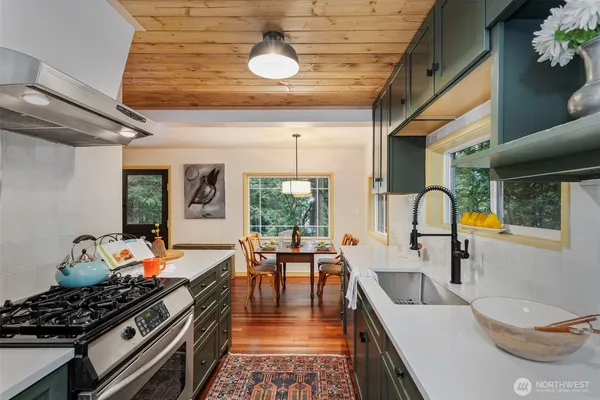 a kitchen with stainless steel appliances granite countertop a stove and a wooden floors