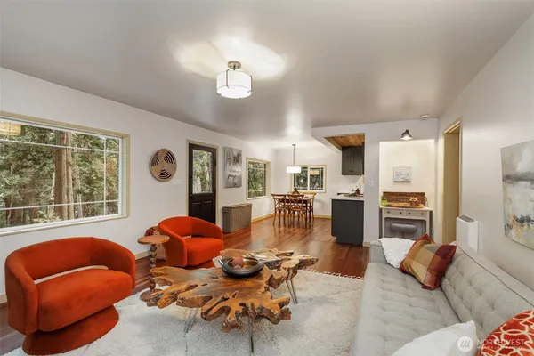 a living room with furniture kitchen view and a large window